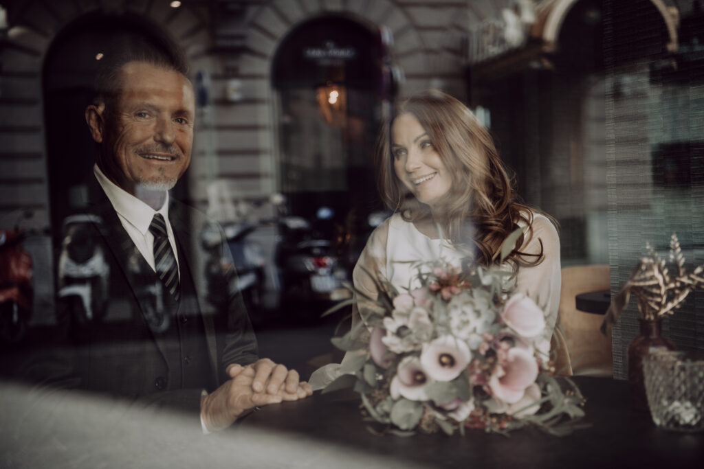 Hochzeitsfotografie- Porträt eines Brautpaares durch eine Glasscheibe fotografiert