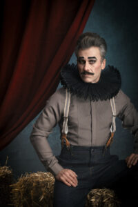 Portraitfotografie- Mann & Frau in Zirkusoutfits vor einem Zirkushintergrund jonglieren mit Köpfen