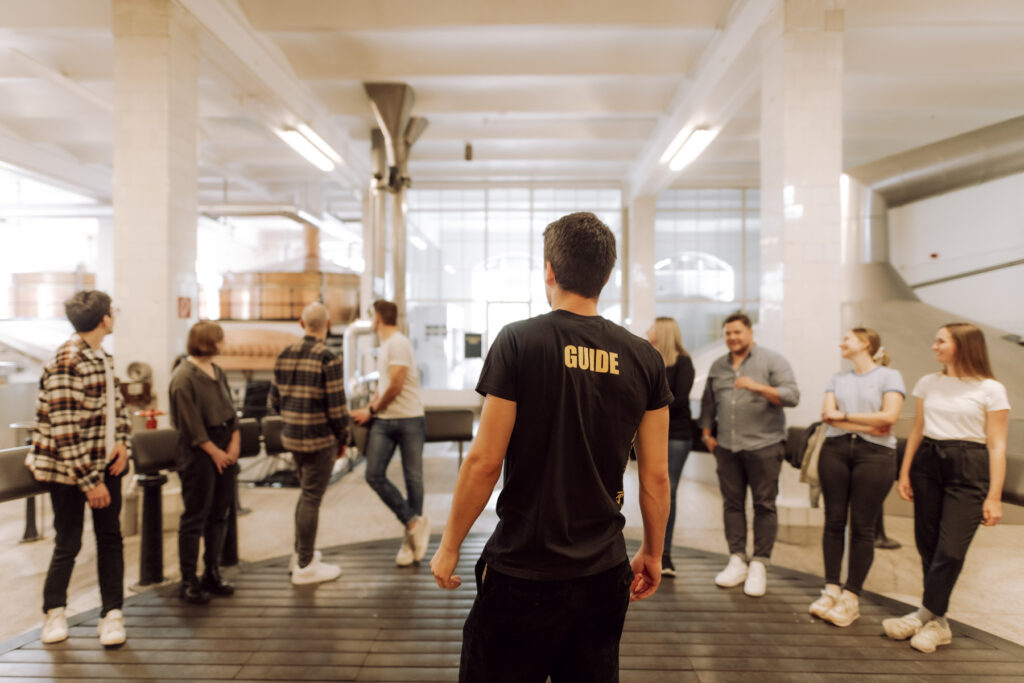 Werbefotografie- Ottakringer Brauerei - junger Mann führt eine Gruppe Menschen durch die Brauerei