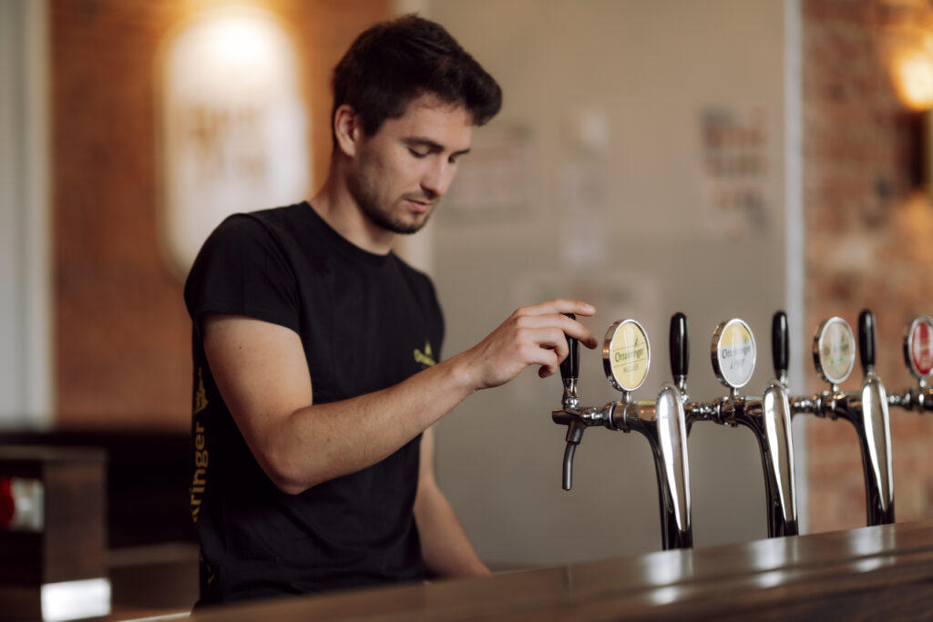 Werbefotografie Brauerei Ottakringer, ein junger Mann, der Bier einschenkt
