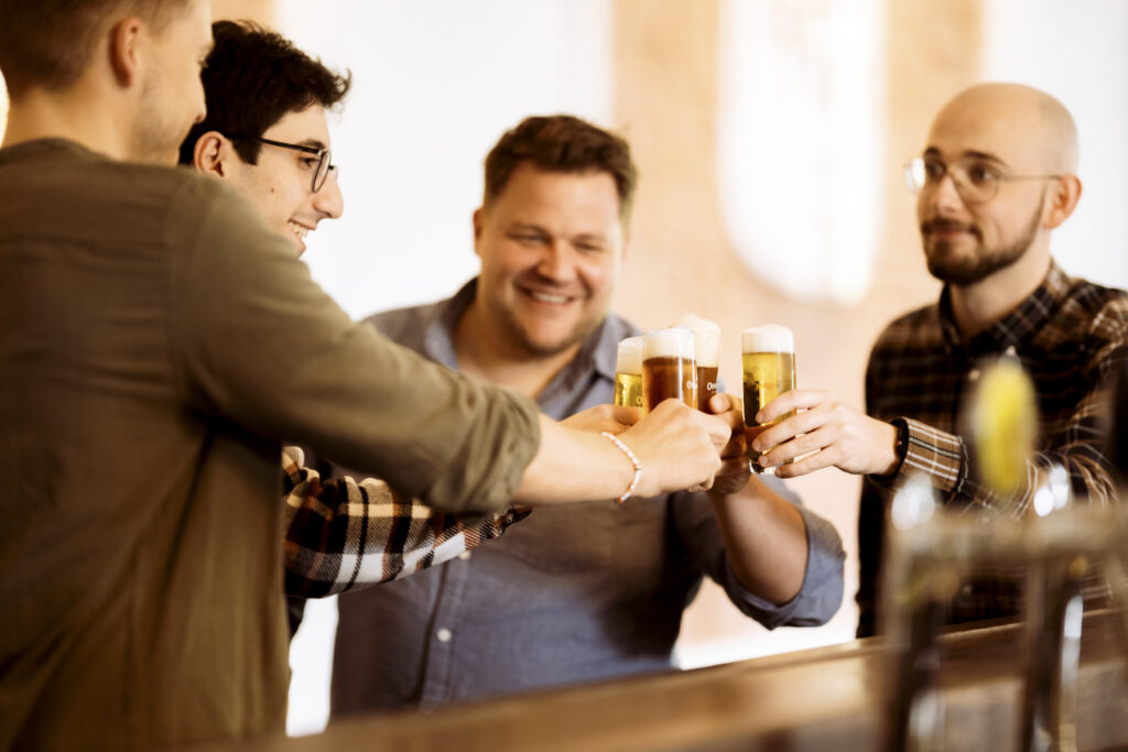 Werbefotografie - Ottakringer Brauerei- eine Gruppe junger Menschen steht an einer Bar und alle trinken Bier und haben Spaß
