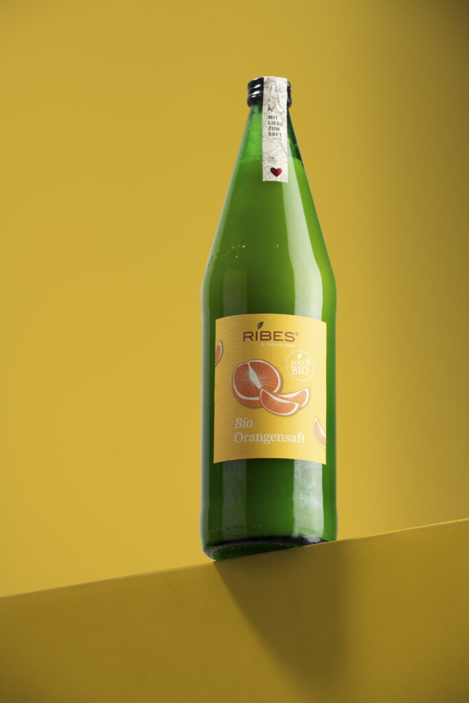 Produktfotografie- Eine Saftflasche der Firma Ribes vor gelbem Hintergrund